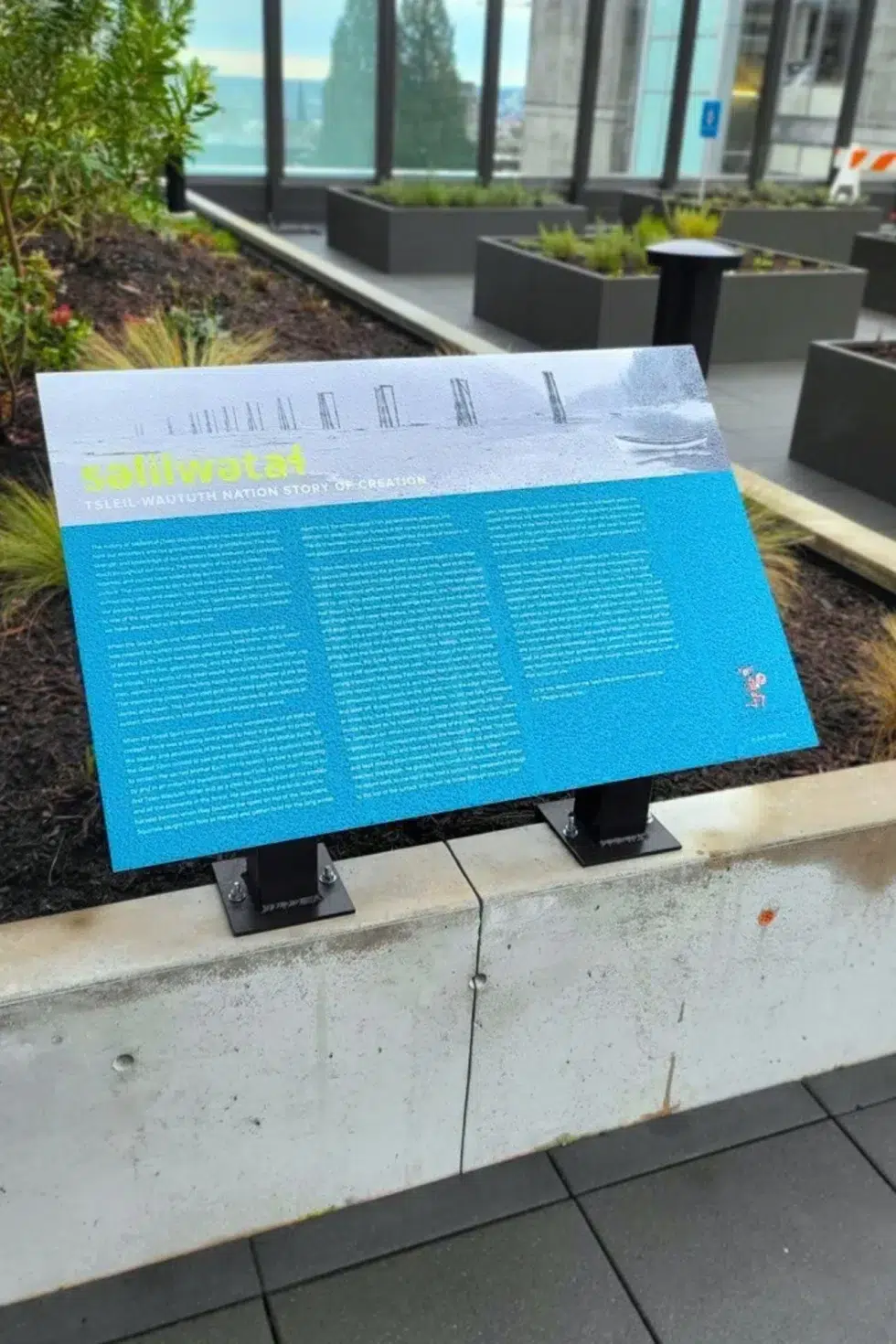 Outdoor interpretive signage displaying the Squamish Nation story of creation at Lions Gate Hospital's rooftop garden.
